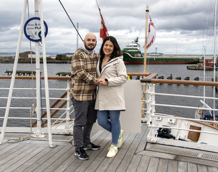 A man and woman embrace newly engaged on the Verandah Deck.