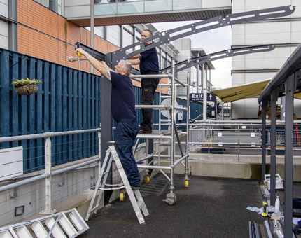 Two men from the Facilities team measuring up for the new canopy that will cover Coweslip.