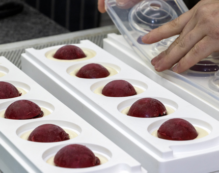 A Chef preparing a cherry sorbet dessert in the Galley kitchen.