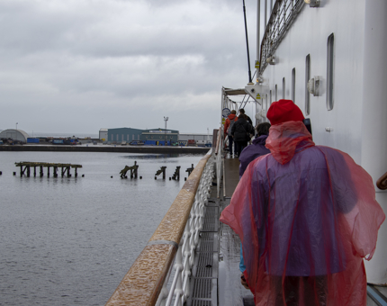 Visitors wearing rain ponchos walk on the outside deck at Britannia.