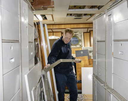 A member of the Maintenance team inspecting the man overboard davit. 