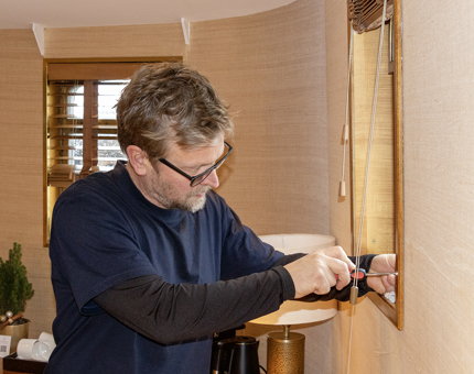 A man tightens up screws on a porthole on Fingal. 