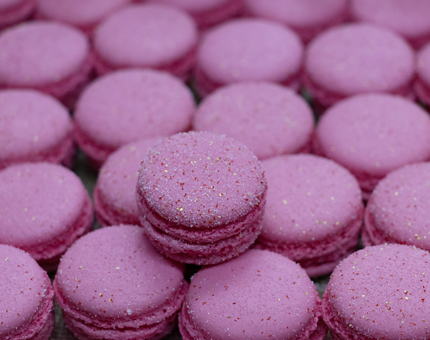 A tray of bright pink macarons. 