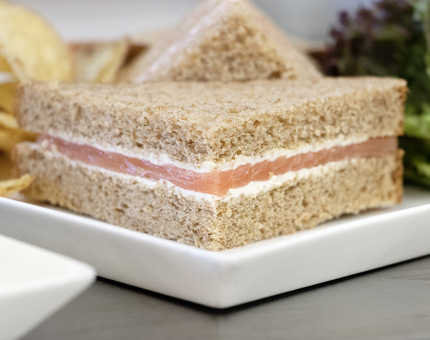 A smoked salmon and cream cheese sandwich on a plate.