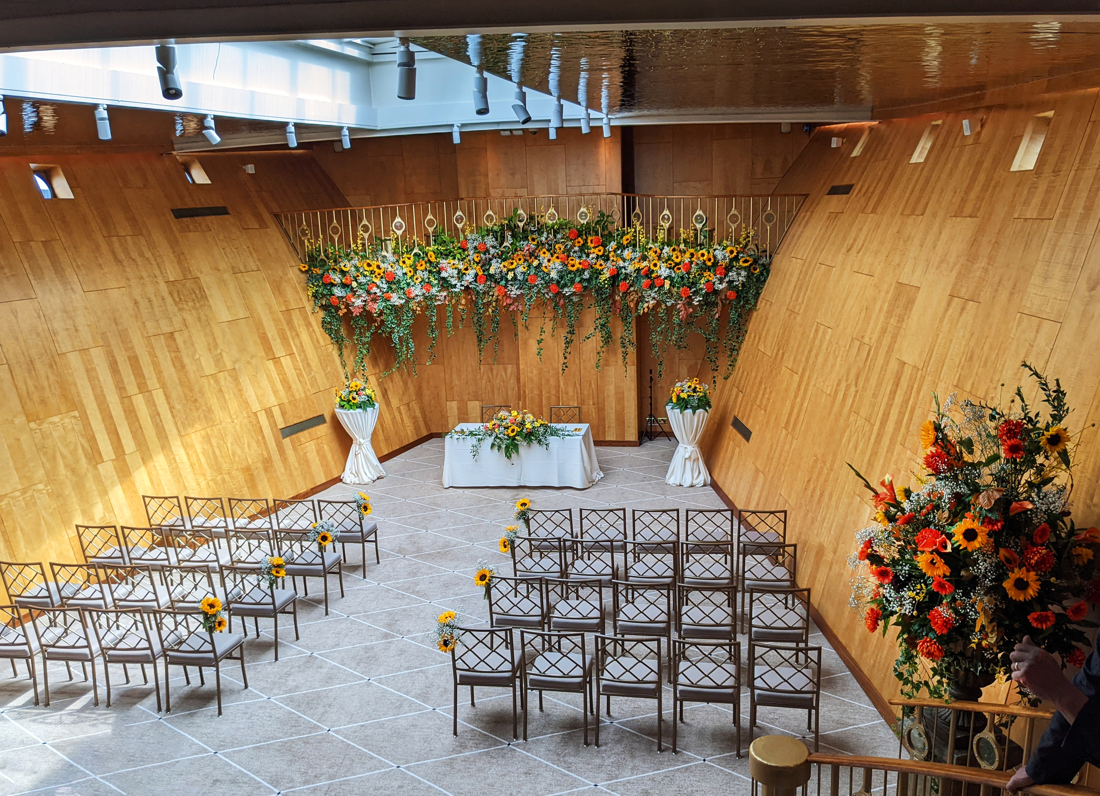 Fingal's Ballroom with flowers decorating the raised gallery and many chairs set up for the wedding ceremony.