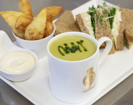 A platter from the Tearoom containing a sandwich, mug of soup, dish of potato wedges and a pot of mayonnaise.