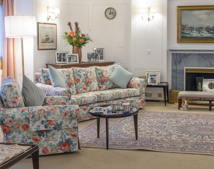 The State Drawing Room with floral-print sofas, a coffee table and fireplace.