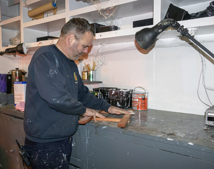 Man in blue jumper working with tools 