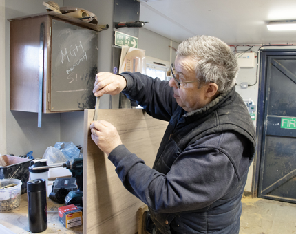 Man in blue coat working 