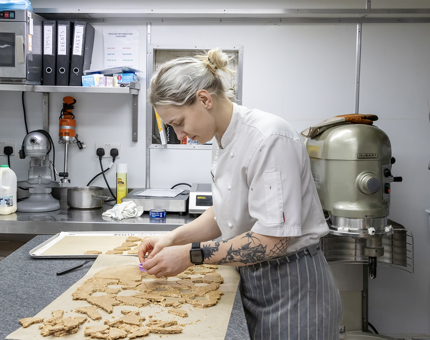 A Pastry Chef making almond bases for a dessert. 