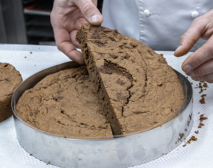 Chocolate brownie is removed from a tin cake mould. 