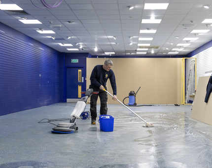 A man from the Maintenance team mopping and buffing the floor in the new temporary Gift Shop. 