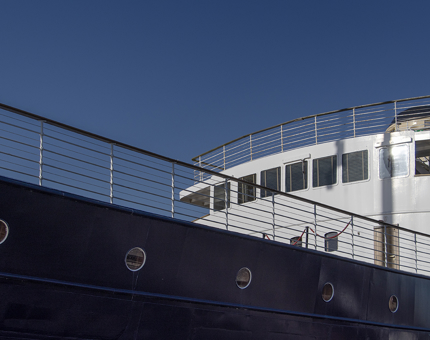 The exterior of Fingal. The hull is navy blue and the outside of The Lighthouse Restaurant & Bar is white.