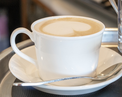 A cup of coffee in a white cup and saucer. 