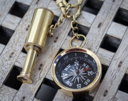 A brass telescope and compass novelty keyrings.