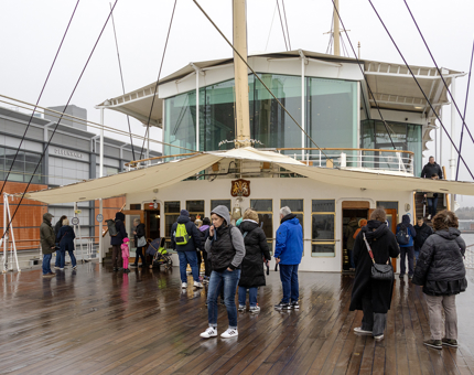 Visitors on the Verandah Deck outside the Sun Lounge on a rainy day. 