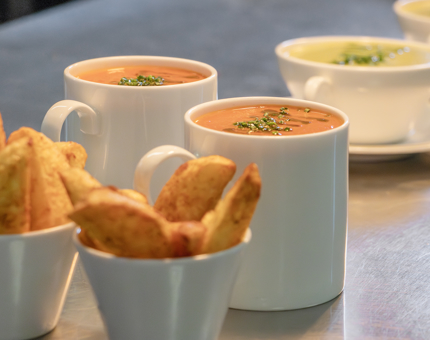 Mugs of soup and bowls of potato wedges in the Galley. 