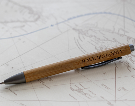 A bamboo pen engraved with H.M.Y Britannia sitting on a map.