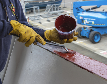 A close-up of a handrail being painted. 