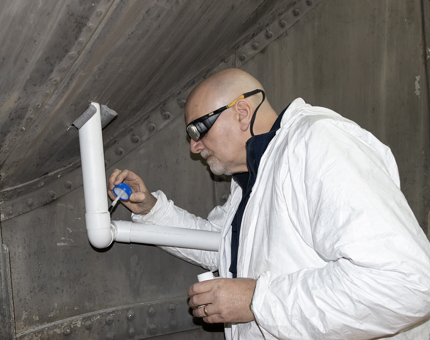 A man from Maintenance working inside the ship's Funnel.