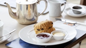 A table in the Royal Deck Tearoom containing a scone, jam, cream and a silver pot of tea. A table in the Royal Deck Tearoom containing a scone, jam, cream and a silver pot of tea.