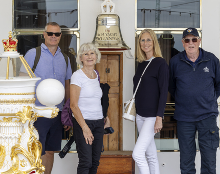Two men and two women stand next to Britannia's Bell and Binnacle.