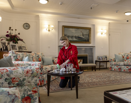 A woman from the Housekeeping team is polishing a teaset in the State Drawing Room.