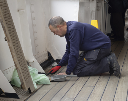A member of the Facilities team is cleaning at the top of the Royal Brow.