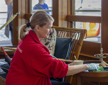 A woman from Housekeeping is cleaning a table in the Sun Lounge.