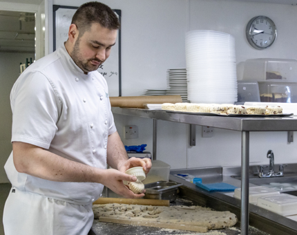 A chef is making scones in the Galley. 