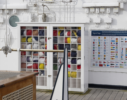 A cabinet containing signal flags on the Bridge of the Yacht.