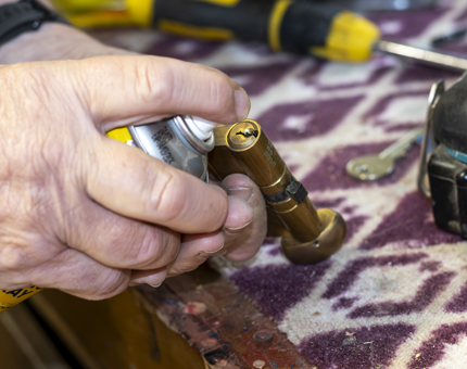A close up of a hand fixing a lock. 