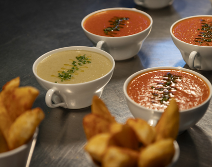 Four bowls of soup and two bowls of wedges. 