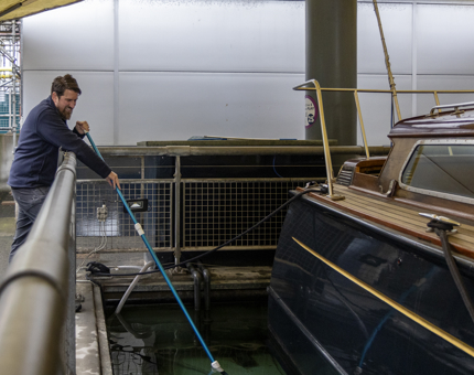 A member of the Maintenance team cleaning the barge pond. 
