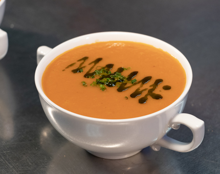 A bowl of tomato and red pepper soup. 