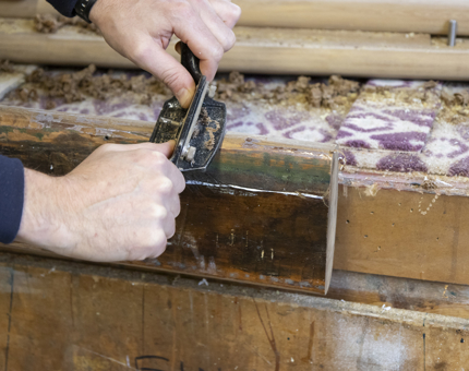 A closer look at wood being plained for a handrail. 