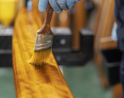 A close up of varnishing a handrail. 
