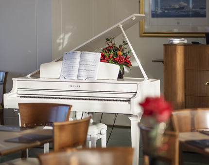 A white grand piano in the Royal Deck Tearoom.