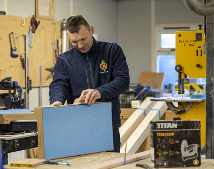 A man sanding a step for a boat. 