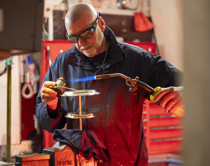 A man braising a cake stand to make it more stable. 