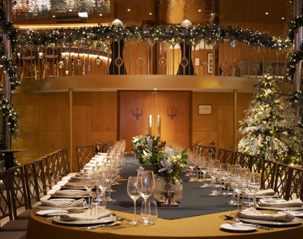 The Ballroom of Fingal Hotel with a long table set for an event. There are Christmas decorations adoring the room and table. 