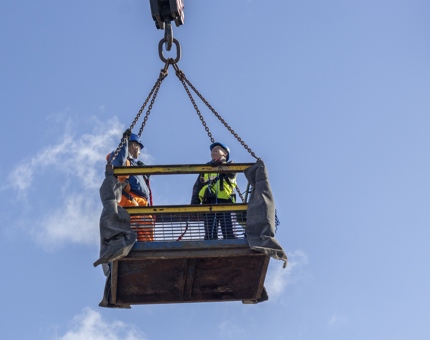 A man from the Maintenance Team is carried in a man basket.