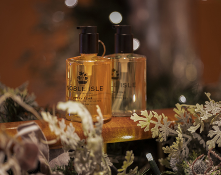 Two bottles of Noble Isle bath and body products. 