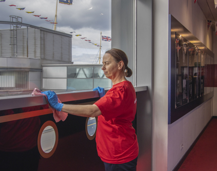 A woman polishing a handrail.