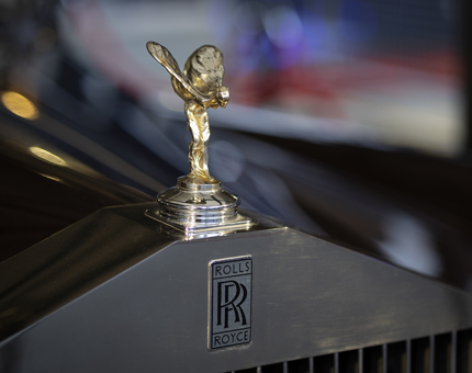 A closeup of a hood ornament on the Rolls-Royce car.