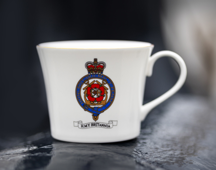 A white mug with a coloured Britannia crest on it.