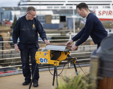 Two Maintenance men cutting wood for Fingal Hotel's Lighthouse Restaurant & Bar extension. 