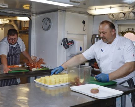 Two Chefs preparing vegetables in the Galley.