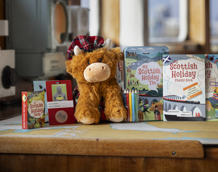 A highland cow soft toy with a selection of children's activity books.