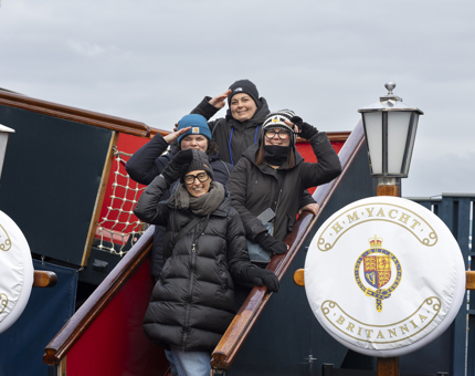 Four women stand on the Royal Brown posing for a photo.